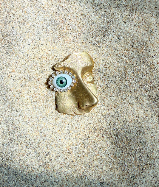 Gilded artifact face brooch