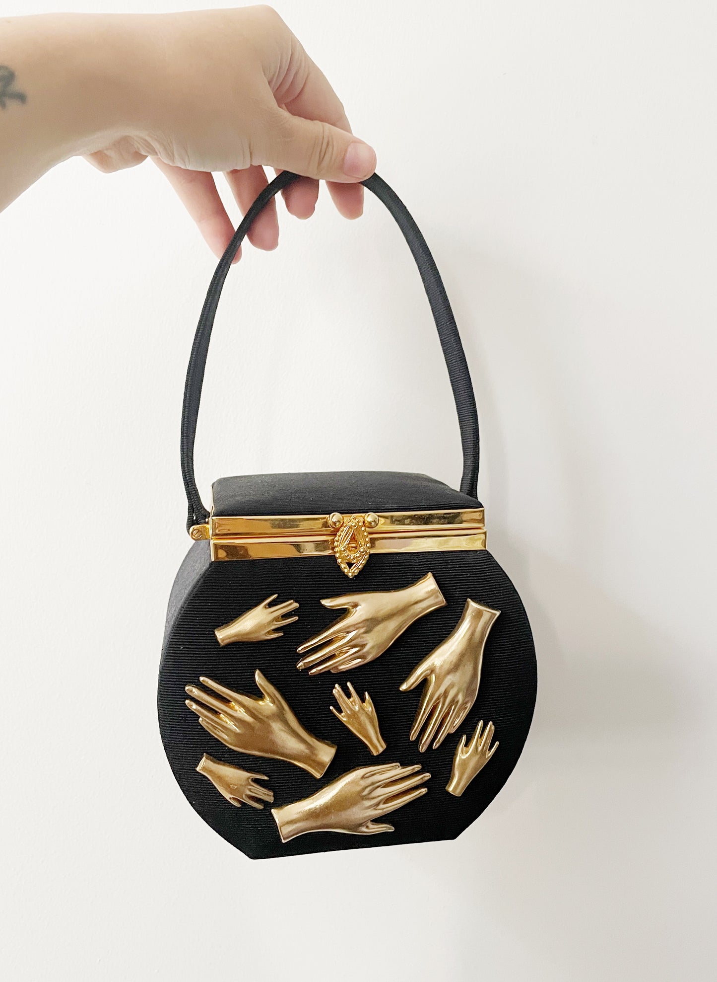 gallery wall hands in purse