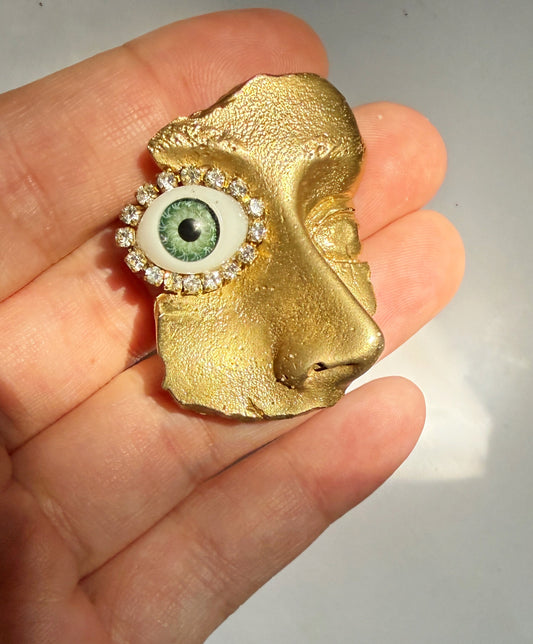 Gilded artifact face brooch